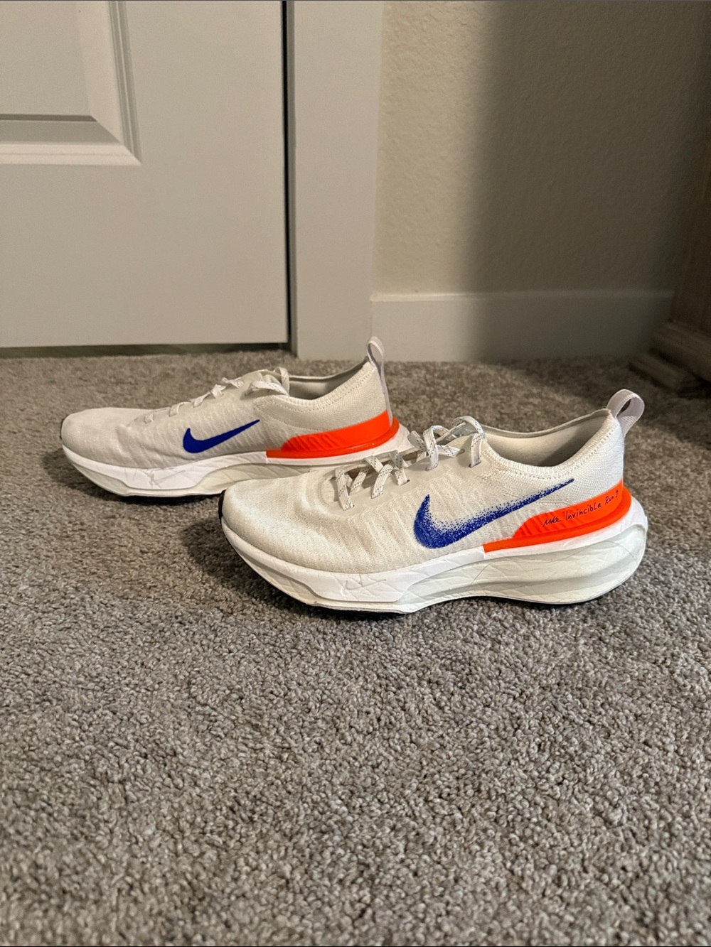 Nike Kids White Sneakers with Blue Swoosh and Orange Heel Accent